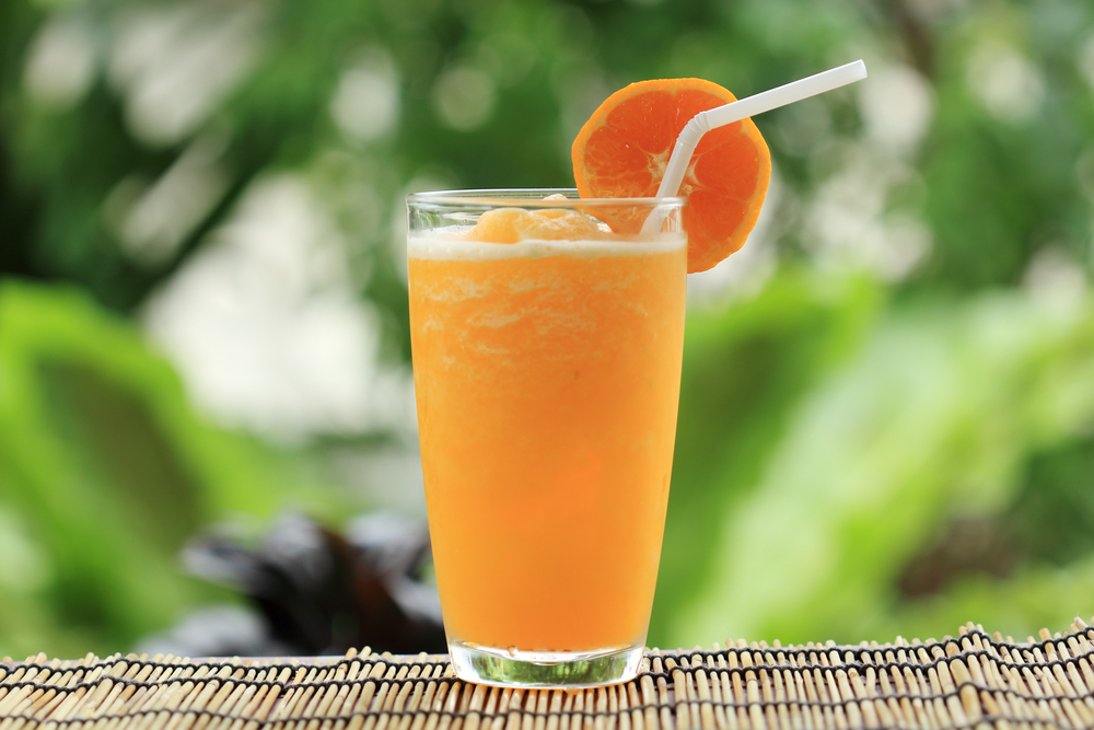 Orange smoothie in a glass outside