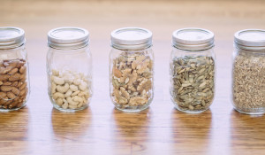 Five jars with nuts and seeds.
