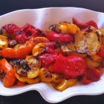 Grilled red and yellow peppers on a white wavy plate