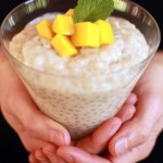 Coconut and tapioca pudding with mango on top in a glass