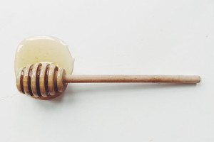 A honey dipper with some honey on it